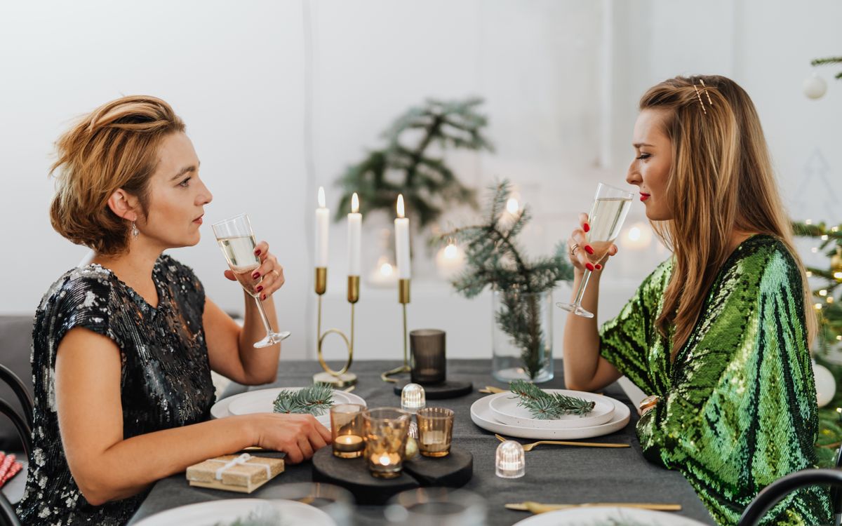 Two women enjoying dinner by candlelight at a restaurant table