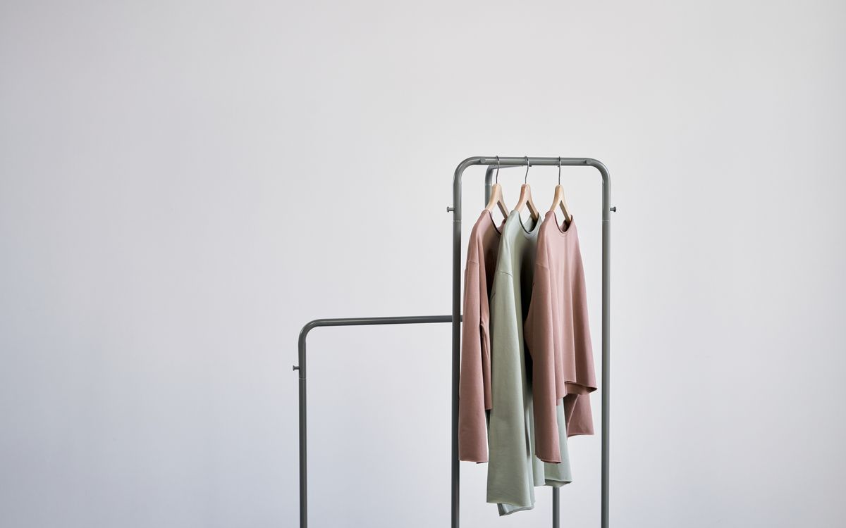 White and brown clothes hanging on a gray metal rack