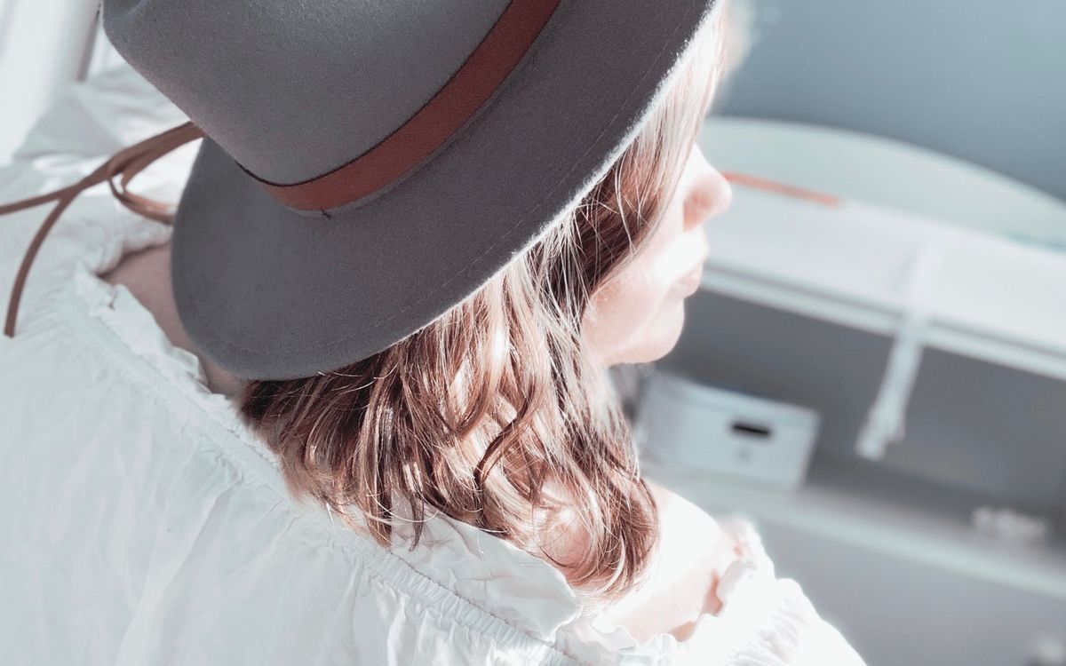 A woman wearing a gray fedora hat