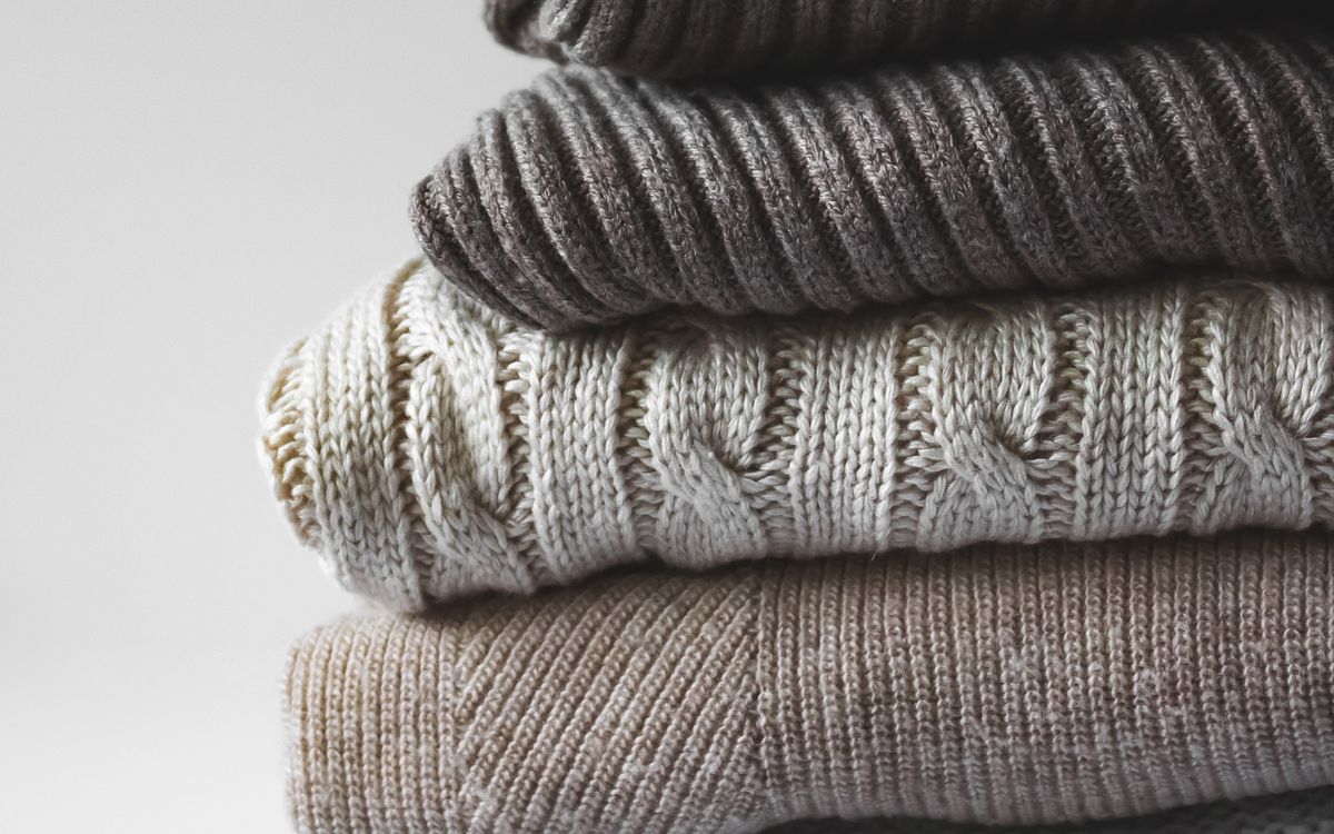 A close-up of knitted sweaters on a white surface