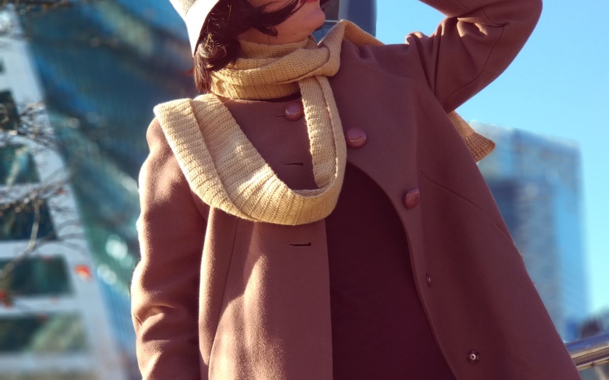 A stylish woman in winter fashion outside a modern building