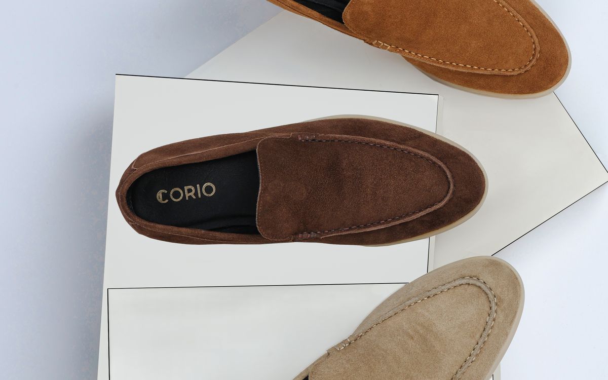 A top view of stylish suede loafers on their boxes