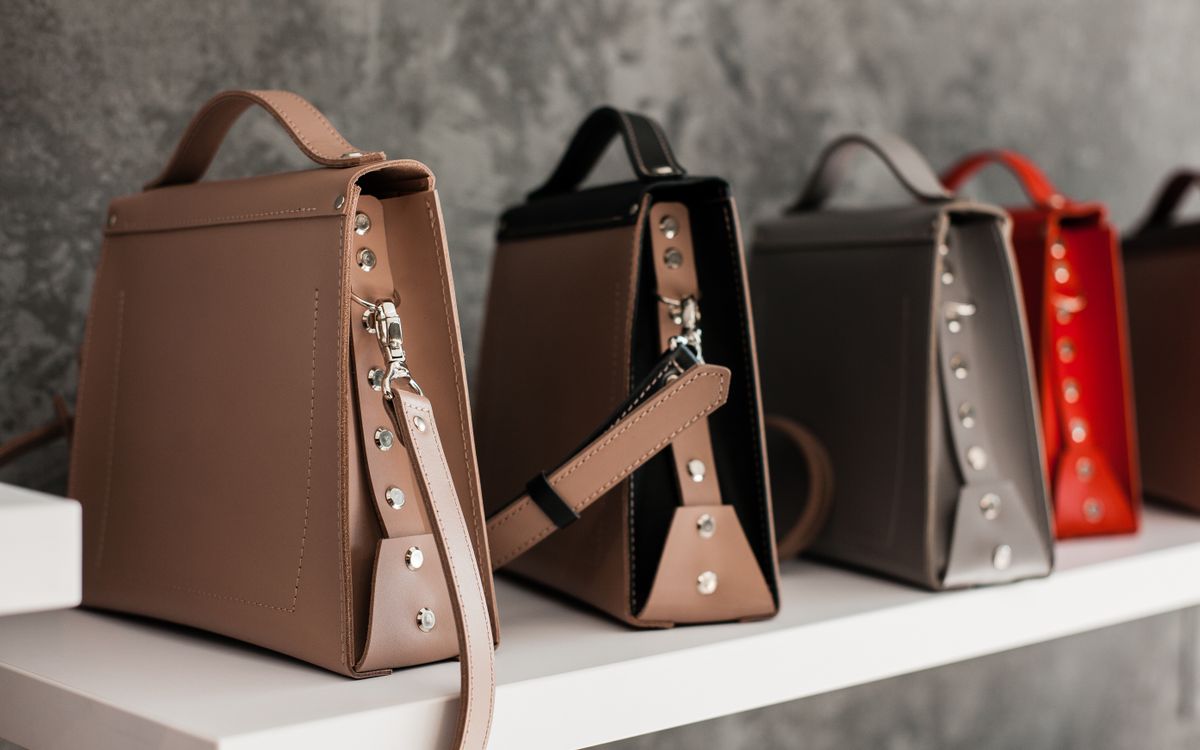 Leather bags on a white wooden shelf