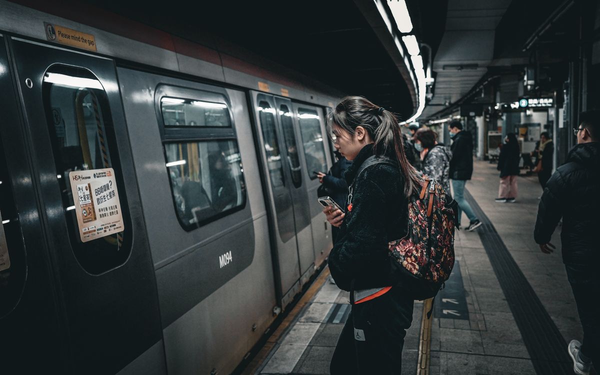 People standing on a platform as a subway train approaches